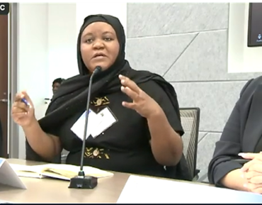 Amina Abubakar seated and speaking into microphone