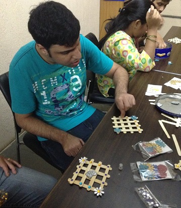 teen in a blue shirt sitting at a table working on a letter activity