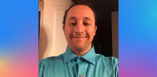 Jordan B. wearing a blue collared shirt and smiling for a selfie