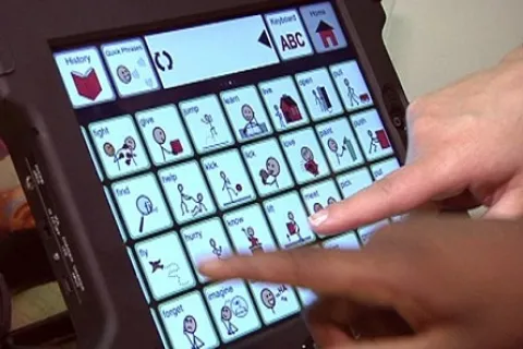 2 hands touching an iPad and using assistive technology to communicate
