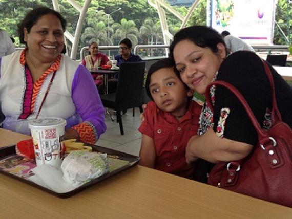 Mrs. Kamini Lakhani at a lunch table with a friend and child