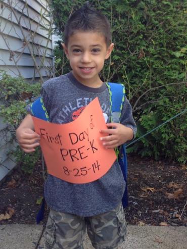 Chase holding a sign for the first day of pre-k