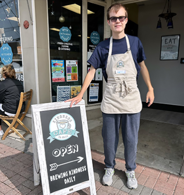 Warren wearing an apron while working at Kindness Cafe on Main