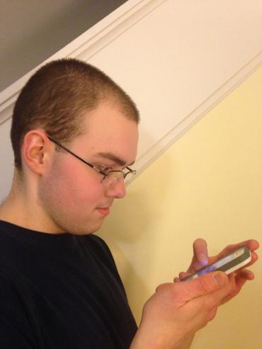 Patrick Vaillancourt looking at an iPhone