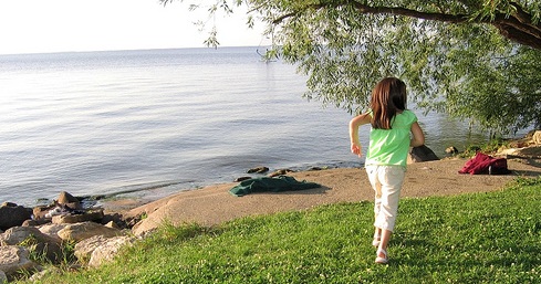 child running by a lake