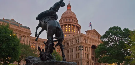 Texas state capitol with cowboy statue in front of building