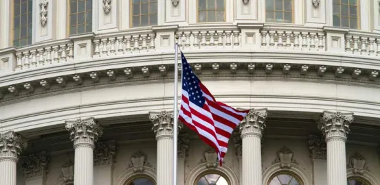 American flag Waving Near White Concrete Building