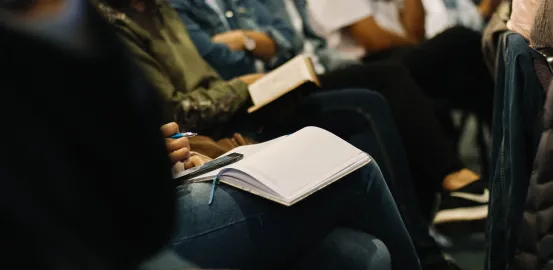 people taking notes at a conference