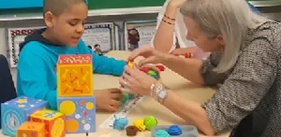 A mom works with a child who has autism during a Caregiver Skills Training workshop. Photo courtesy Mom2Mom
