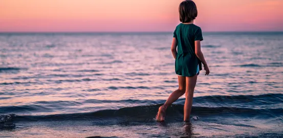 Child wandering alone by the ocean
