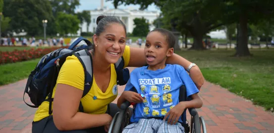Woman and young child with autism in wheelchair in front of White House