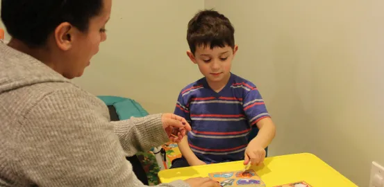 boy working with therapist at small table