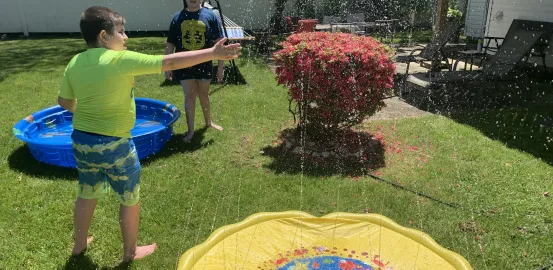 James Guttman's children playing in a sprinkler. 
