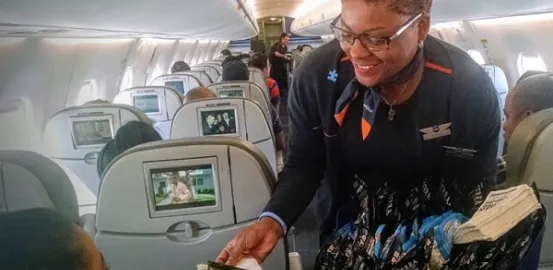 Jet Blue stewardess wearing an Autism Speaks pin while passing out snacks on a flight