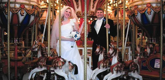 Ron Sandison and his wife standing on a carousel on their wedding day