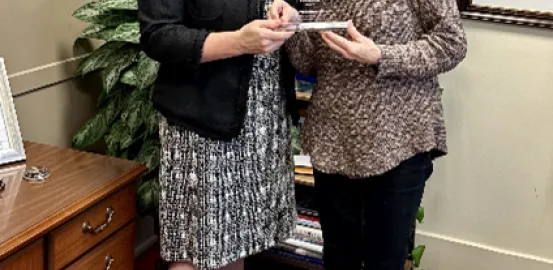 Autism Speaks State Government Affairs Director Christa Stevens presenting Texas State Representative Donna Howard with clear puzzle piece shaped award