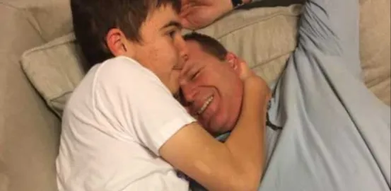 Stephen hugging his dad on the couch