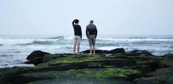 Two people looking at the ocean