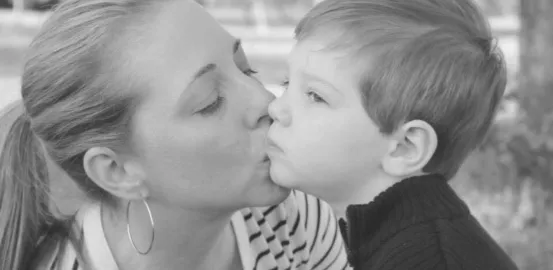 A mom kissing her young child