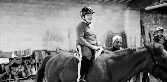 child riding a horse as a form of equine therapy for autism