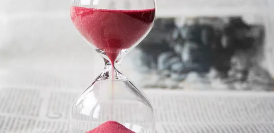 hourglass with red sand on a table