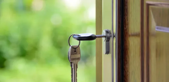 keys to a house hanging from the door knob