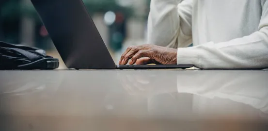 laptop on a table being used by a man in a suit