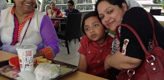 Mrs. Kamini Lakhani at a lunch table with a friend and child