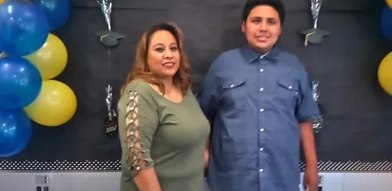 mother and son standing under a balloon arch