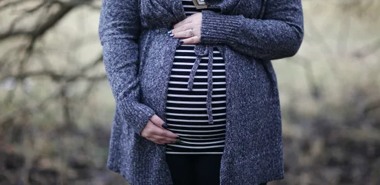 pregnant woman wearing a striped shirt and holding her baby bump