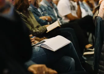 people taking notes at a conference