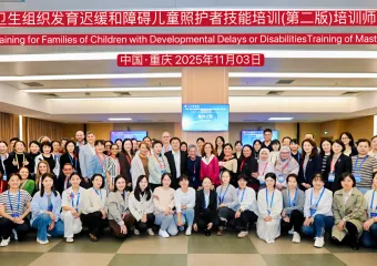 Large group of conference attendees posing for a photo outside a modern building with event banner above them