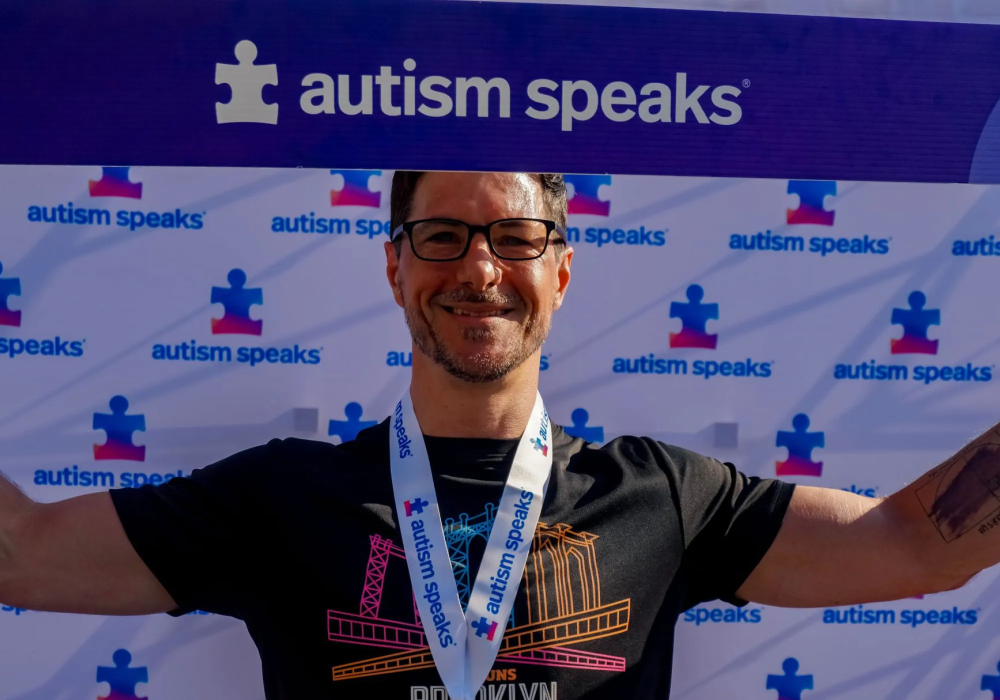 Man celebrating completion of Autism Speaks Empower Walk + 5K Run