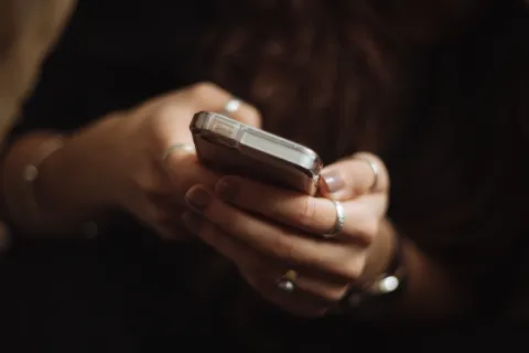 A woman's hands holding a cell phone