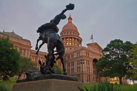 Texas state capitol with cowboy statue in front of building