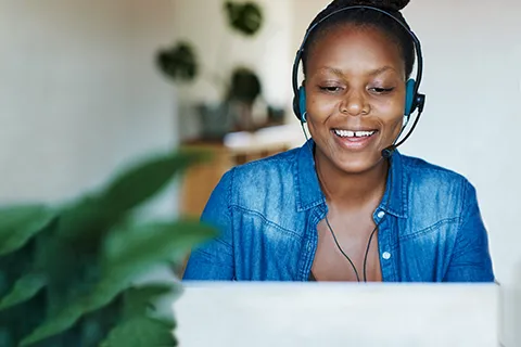 An African American woman in front of a computer with a call center headset