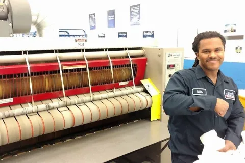 A Cintas employee with autism operates the napkin press.