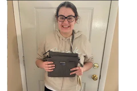 Photo of Alyson holding the bag she keeps her wallet in when she goes out shopping