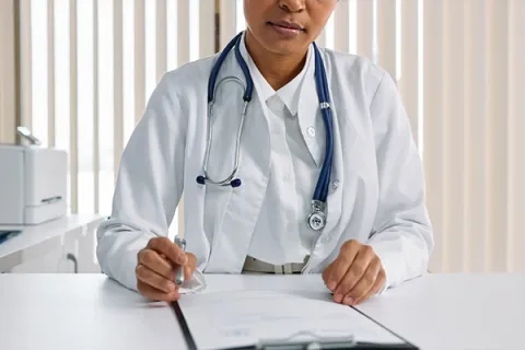 Doctor at their desk with a clipboard