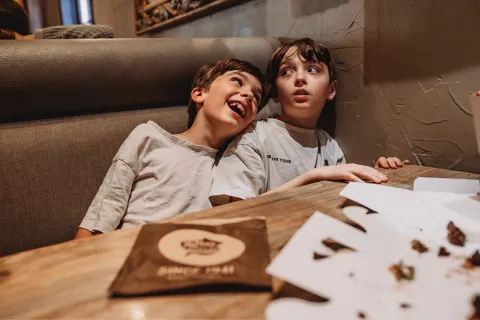 Eileen Lamb's children, Jude and Charlie sitting in a booth at a restaurant