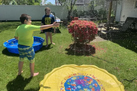 James Guttman's children playing in a sprinkler. 