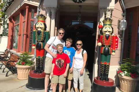 Jeff McCafferty, his wife and two sons in front of life size nut crackers