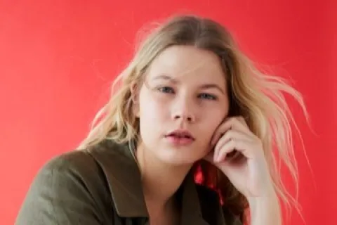 Melissa Koole modeling in front of a red backdrop
