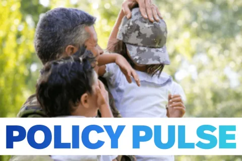 man with arms around two children wearing army camo