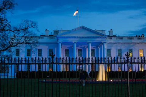 The White House with blue lighting at night to support autism