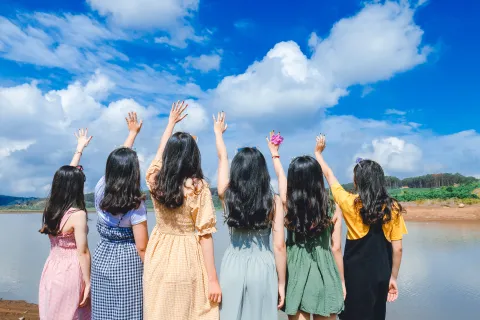 a group of girls with long black hair and their arms in the air