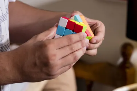 hands holding a colorful Rubik's cube