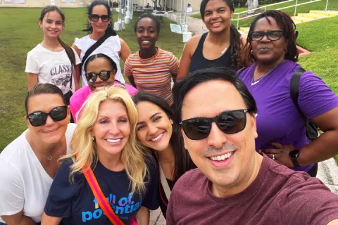 Autism Speaks staff member taking a selfie with group of people at a local event