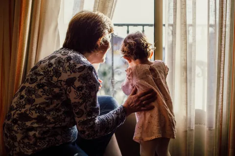 grandma and granddaughter looking out the window