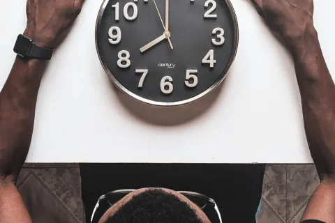 man staring at a clock on the table